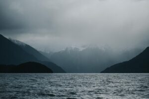 fog-covered mountain near body of water